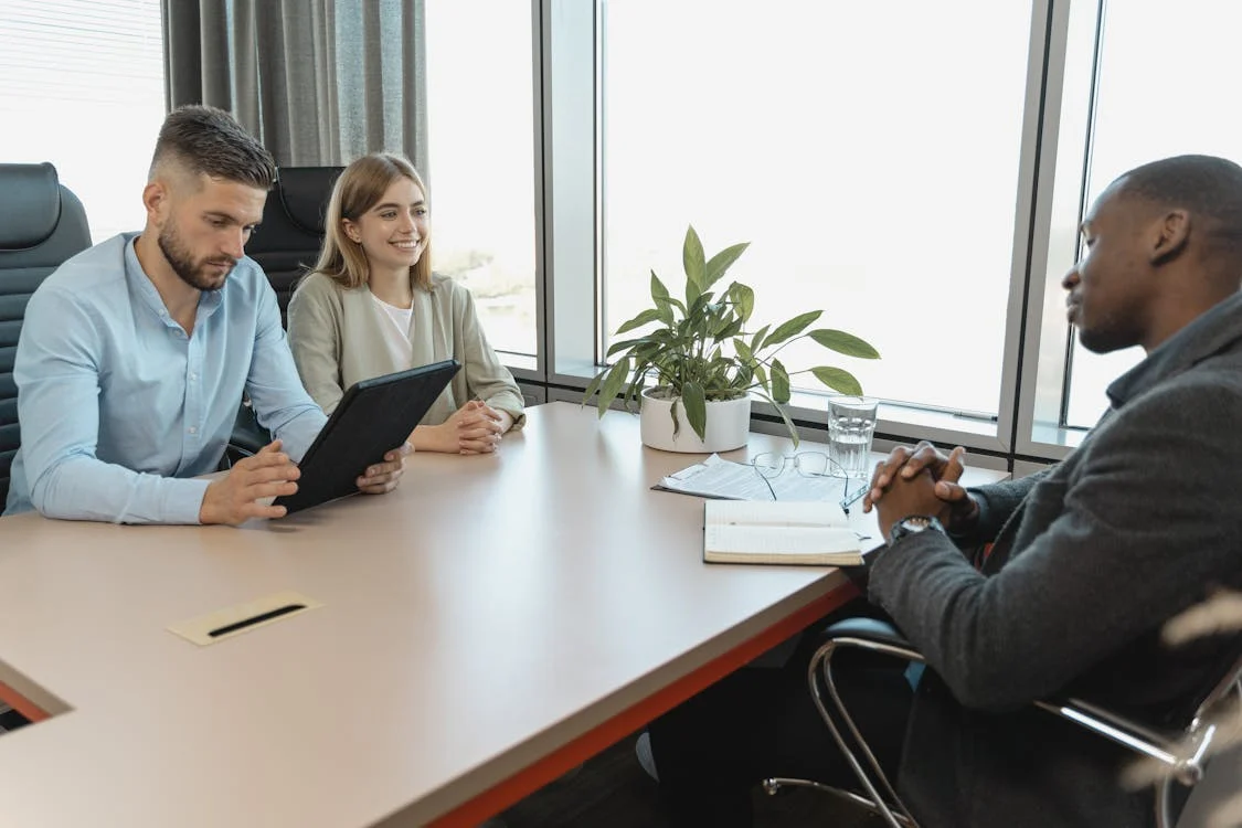 employer interviews candidate in an office, both are smiling