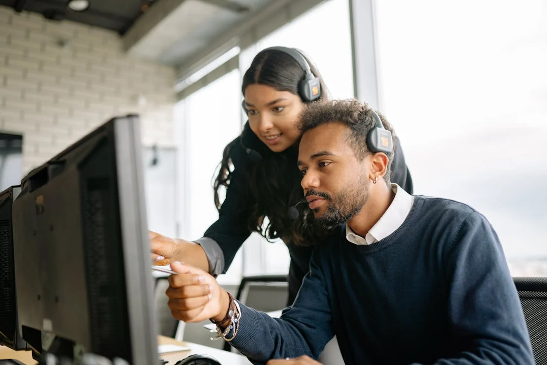 two people look at candidate matching software on an illuminated screen, one of them pointing at the screen