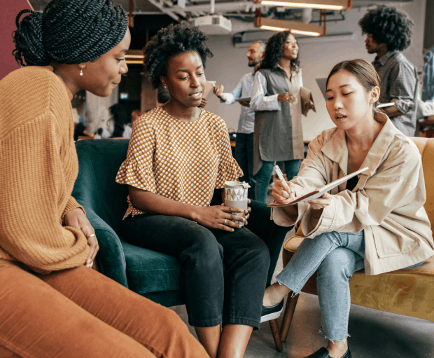 Diverse group of female HR professionals discussing latest results in relaxed office setting