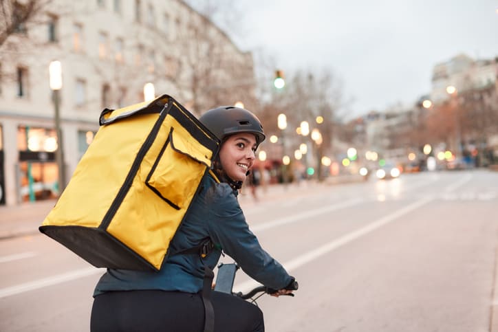 A Delivery biker looking over their shoulder.